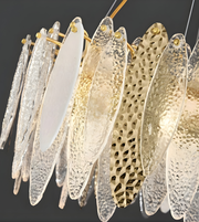 Decorative chandelier with glass leaves in various patterns and colors on a dark background