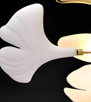 Modern wall sconce with white ceramic shade and gold fixture on a black background