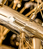 Close-up of a gold musical instrument with blurred lights in the background