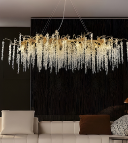 Luxurious chandelier hanging above a modern living room with a black wall.