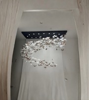 Modern chandelier hanging from a ceiling in a room with light-colored walls.