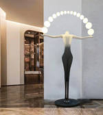 Decorative floor lamp shaped like a woman with circular light bulbs on her head in a modern interior setting.