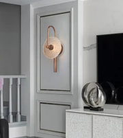 Decorative wall sconce in a modern interior setting with a television and decorative items.