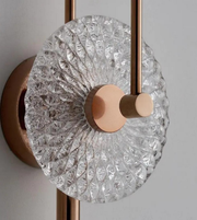 Decorative wall light fixture with crystal design and bronze finish on a neutral background