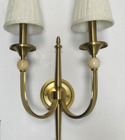 Brass wall sconce with two lampshades on a white background