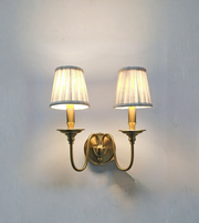 Pair of wall sconces with lampshades on a plain wall