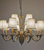 Bronze chandelier with white lampshades on a gray background