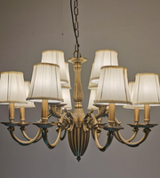 Bronze chandelier with white lampshades on a gray background