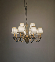 Vintage-style chandelier with six lampshades on a plain background
