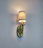 Wall-mounted light fixture with a fabric shade on a plain wall.