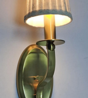 Brass wall sconce with a lampshade on a white background