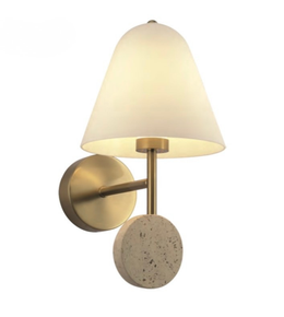 Wall-mounted light fixture with a white shade, gold arm, and concrete base on a white background