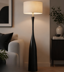 Black floor lamp in a living room setting with a beige sofa and decorative items.