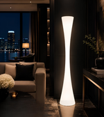 Tall floor lamp in a dimly lit living room with cityscape view