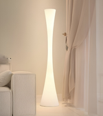 Floor lamp casting light on a curtain in a softly lit room