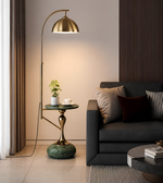 Modern living room with a gold floor lamp, black sofa, and side table.