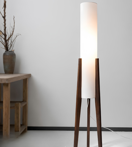 Floor lamp with wooden base and white cylindrical shade in a minimalistic room.