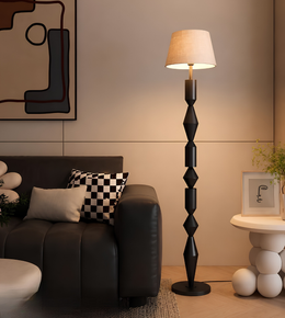 Modern living room with a black floor lamp, sofa, and abstract art on the wall.