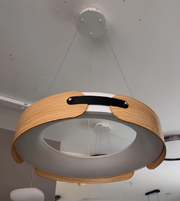 Modern pendant light with wooden frame and glass shade hanging from the ceiling.