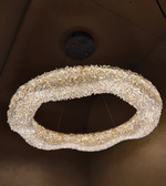 Decorative wreath made of pearls hanging on a dark wall.