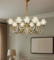 Luxurious chandelier hanging in a room with a lamp and framed picture on the wall.