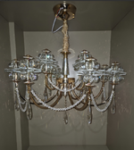 Crystal chandelier hanging from a ceiling in a room with white walls.