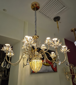 Crystal chandelier hanging from a ceiling with a neutral background