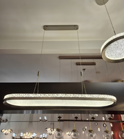 Modern chandelier hanging from a ceiling with a neutral background