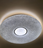 Round ceiling light fixture with textured surface and central circular design on a neutral background