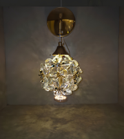 Decorative wall light fixture with crystal-like design on a plain background