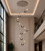 Modern chandelier hanging in a stylish interior setting with large windows and neutral walls.