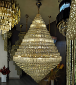 Large crystal chandelier in a showroom setting with other chandeliers.