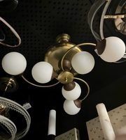 Close-up of a chandelier with multiple light bulbs on a dark ceiling.