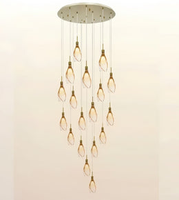 A modern multi-light chandelier pendant fixture with a circular brushed metal ceiling canopy, multiple hanging rods, and twelve clear glass teardrop-shaped bulbs arranged in a cascading diamond pattern against a plain light background.