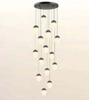 A modern multi-light pendant chandelier with a circular black ceiling mount and multiple hanging frosted glass globes, shown against a plain light background.