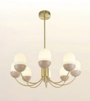 A modern 7-light chandelier with a brushed gold metal frame and frosted white dome glass shades, shown against a plain off-white background.