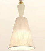 A modern pendant light fixture with a tapered beige linen-textured shade, a white geometric neck, and a gold-toned metal cap, shown against a plain off-white background.