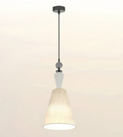A modern pendant light fixture with a black metal rod, a white geometric accent, and a textured cream-colored fabric shade, shown against a plain off-white background.