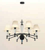A modern 9-light chandelier with a black metal frame, textured off-white drum shades, and white glass cone accents, suspended from a ceiling.