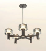 A modern 5-light chandelier with a dark brushed metal frame and clear cylindrical glass shades, shown against a plain off-white background.