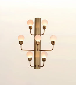 Modern brushed gold wall sconce featuring seven frosted globe lights mounted on a sleek cylindrical metal frame.