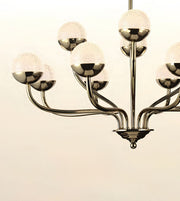 A modern multi-arm chandelier with a polished dark metallic finish and textured frosted glass globes, shown against a plain off-white background.