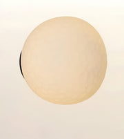 A spherical, textured light fixture or lamp shade in a warm cream or beige color, shown against a plain off-white background.