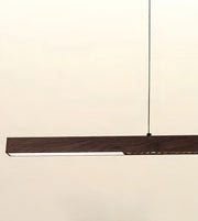 A modern linear LED pendant light with a dark wood-grain finish and a slim black suspension cord, shown against a plain off-white background.
