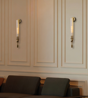 Luxury fluted glass wall light with a brushed gold finish and ribbed glass diffuser, perfect for living rooms, hallways, bedrooms, hotel suites, and contemporary luxury interiors.