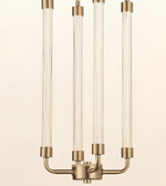 A modern three-light chandelier with clear glass cylindrical tubes and a brushed brass-finished metal base and connectors, shown against a plain off-white background.