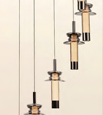 Four modern pendant lights with dark metal shades and textured beige mesh cylinders, suspended by thin black cords against a warm off-white background.