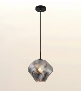 A modern pendant light with a textured, ribbed glass shade in a metallic silver finish, suspended by a slim black cord from a matching black ceiling canopy against a soft, light beige gradient background.