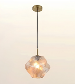 A modern pendant light with a textured, ribbed clear glass shade that glows warm when lit, suspended by a black cord from a round brass ceiling canopy.