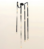 Contemporary cascade LED strap chandelier with illuminated circular light modules for staircases, foyers, double-height living rooms, and luxury interiors.
